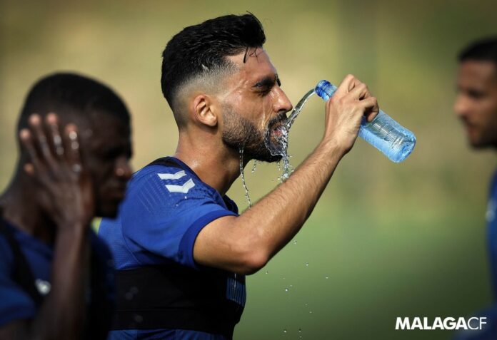 Juande se refresca en un caluroso entrenamiento con el Málaga CF en Estepona | MCF: Pepe Ortega