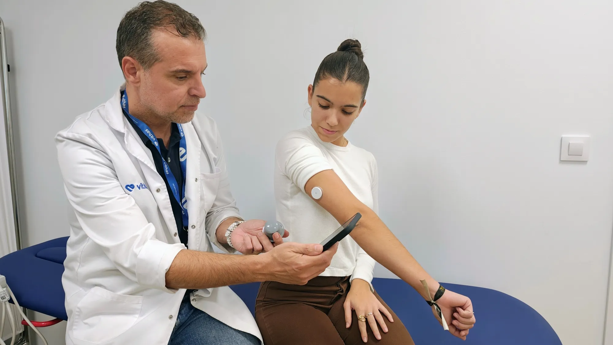El Dr. Morales endocrino de Vithas Sevilla expone el uso del sensor de diabetes a una paciente