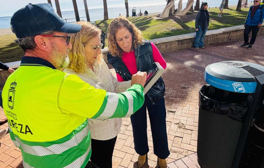 Mula y Diaz atienden las indicaciones que realiza un operario sobre una tablet junto a una papelera con la tecnologia NFC instalada