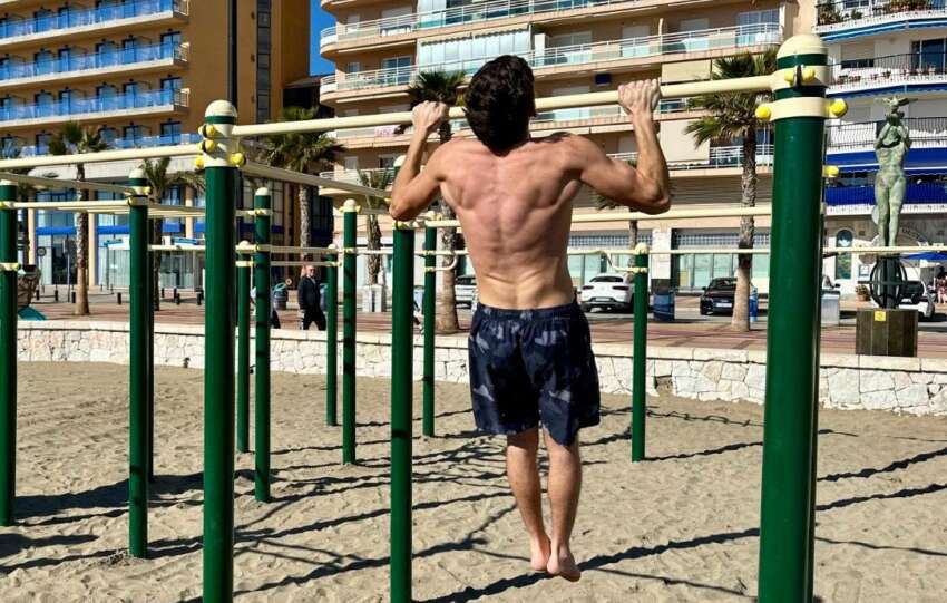 Un deportista practica calistenia en las instalaciones del Paseo maritimo