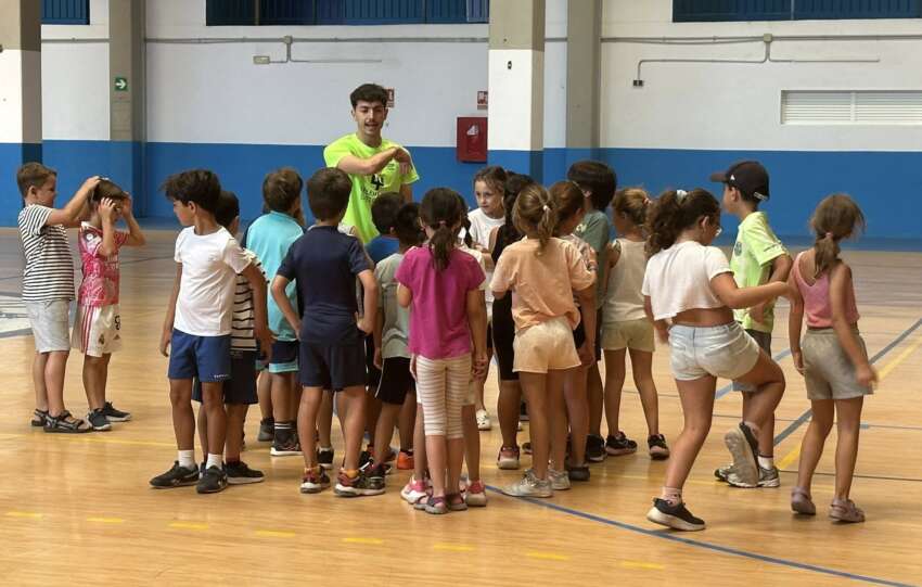 Un grupo de ninos atienden al monitor en una edicion anterior del Campus Deportivo de Verano en el Complejo Elola