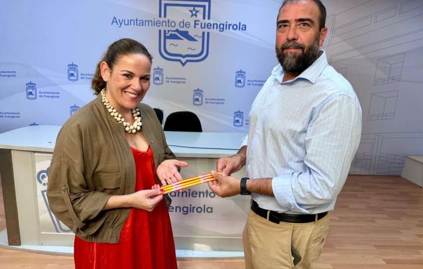 Moreno y Espinosa muestran las pulseras con la bandera de Espana que se repartiran el 12 de octubre